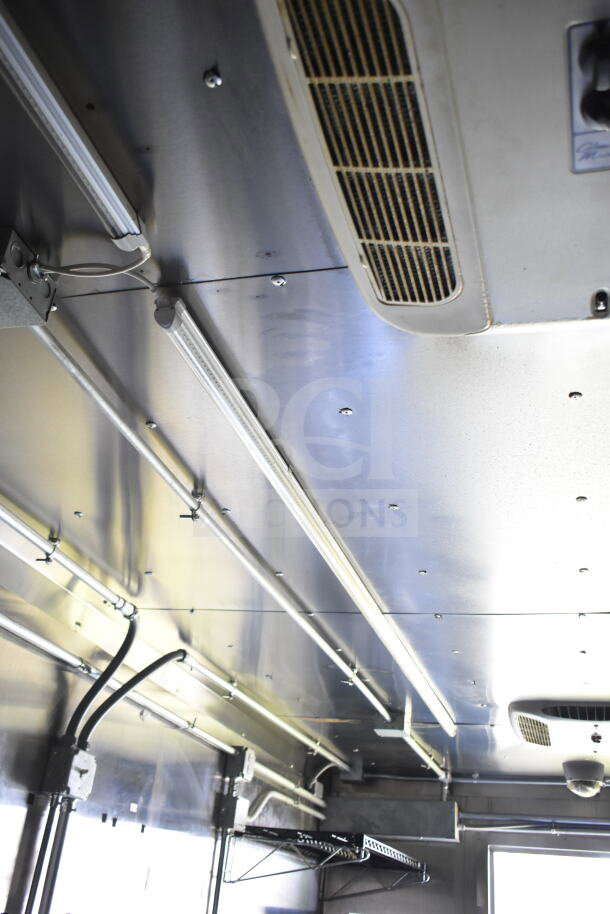 Interior view of 2021 Diamond Cargo 8.5'x24' food trailer showing CaptiveAire grease hood and lighting fixtures in excellent condition.