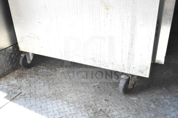 2021 Diamond Cargo food trailer interior; visible are stainless surfaces on wheels, checkered flooring. No visible labels.