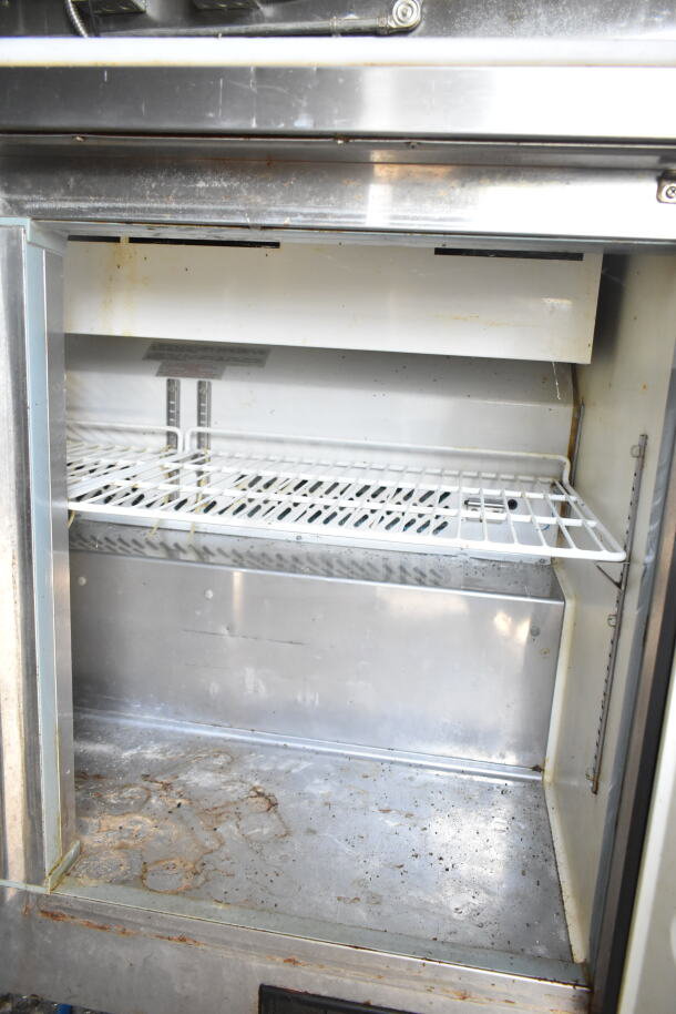 Interior of used refrigeration unit in 2021 Diamond Cargo food trailer, showing wire shelving and signs of wear.