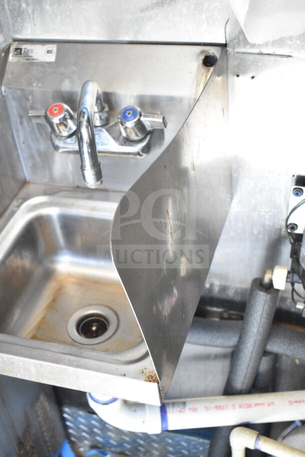 Diamond Cargo food trailer sink detail; stainless steel sink with faucet, visible piping, slight wear.
