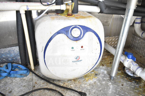 2021 Diamond Cargo food trailer component, Eccotemp water heater shows wear. Visible wiring and pipes attached.