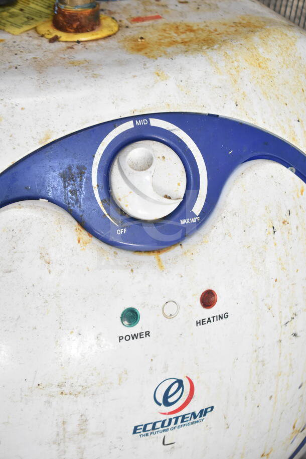 Close-up of a rusty Eccotemp power and heating control panel; surface shows signs of wear and stains.