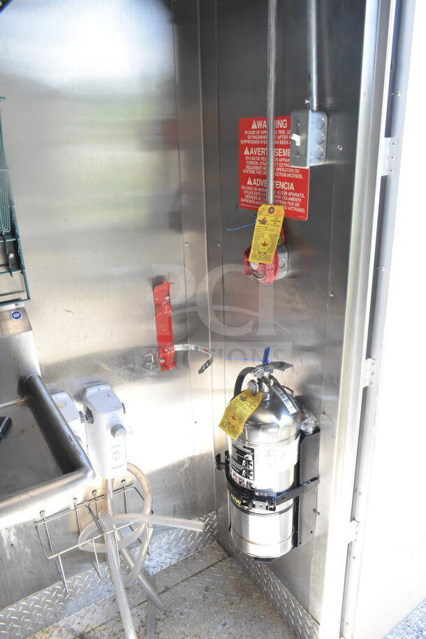 2021 Diamond Cargo food trailer interior showing a fire suppression system with warning labels and extinguishing equipment.
