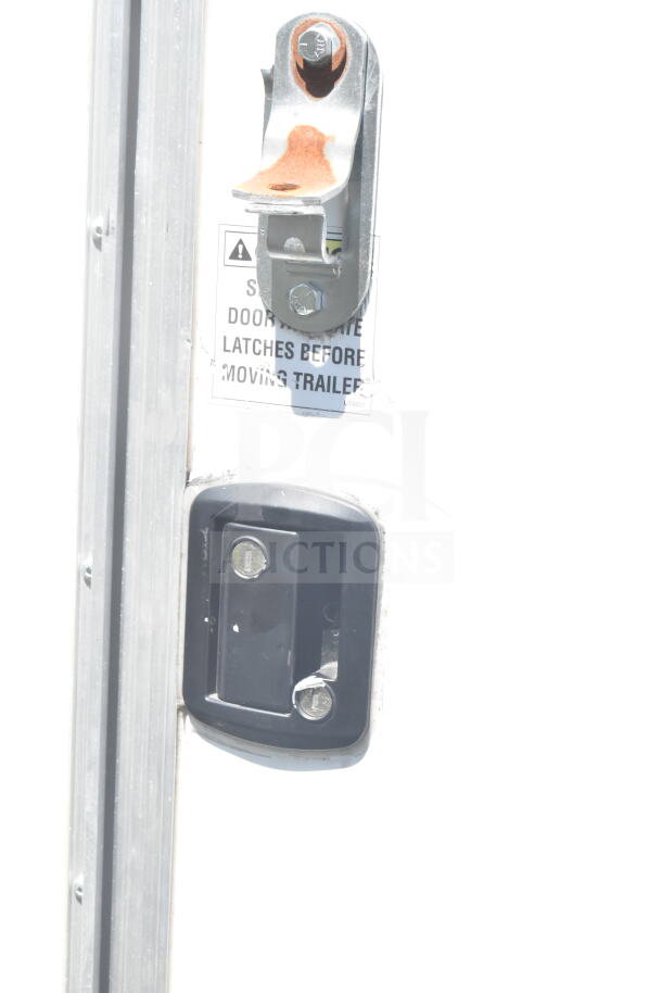 2021 Diamond Cargo food trailer latch close-up; includes visible warning label.