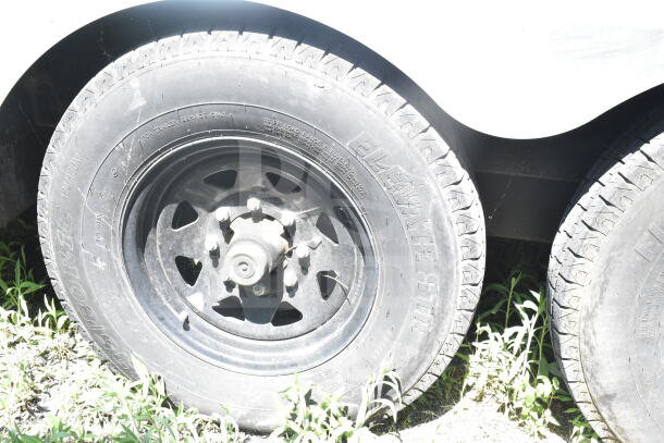 Dual wheel section of a Diamond Cargo 8.5'x24' food trailer, tire markings visible, showcasing its robust design.