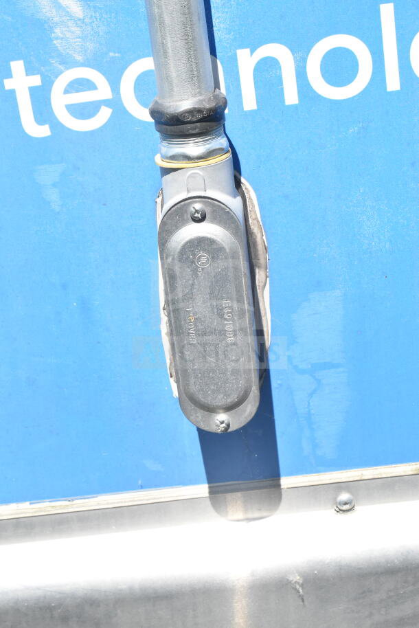Metal fixture on 2021 Diamond Cargo food trailer exterior, showing part of blue technology decal.