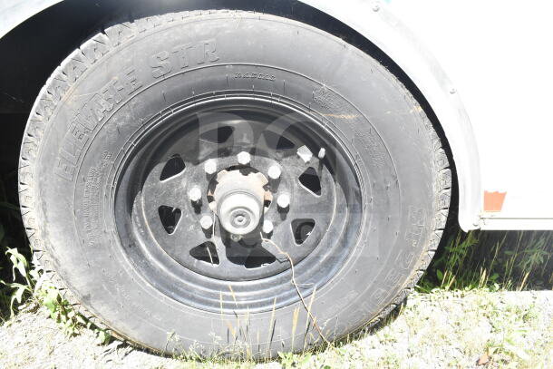 Close-up of a tire on a 2021 Diamond Cargo 8.5'x24' food trailer, featuring "Elevate STR" branding, showing wheel condition.