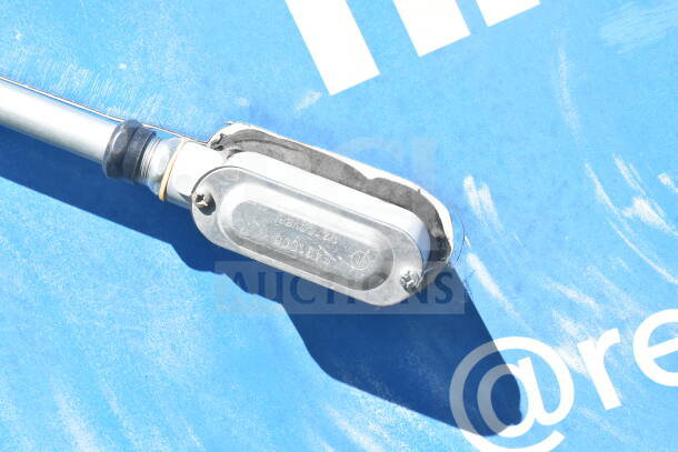 Silver metal junction box cover on a blue background with partial text visible.