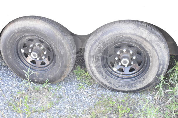Dual wheels of 2021 Diamond Cargo 8.5'x24' food trailer, showing tire condition on gravel ground.