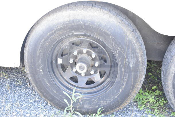 2021 Diamond Cargo 8.5'x24' food trailer wheel, visible tire tread, on gravel surface.