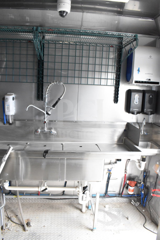 2021 Texino 28ft Popeyes-configured cooking trailer interior. Features include stainless steel sink, CaptiveAire hood, and equipment setup.