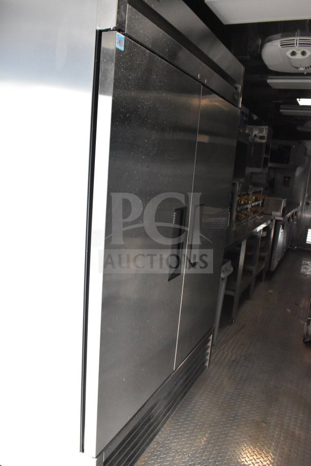 28ft Texino cooking trailer interior, featuring a 2021 True refrigerators suite, showcases stainless steel equipment in excellent condition.