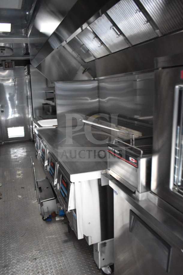 Alt text: "2021 Texino 28ft Popeyes-configured cooking trailer interior, featuring Ultrafryer Ultrastat23 4-bay fryer, CaptiveAire hood, and True refrigeration suite."