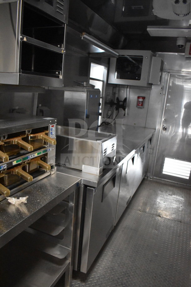 Interior of 2021 Texino 28ft cooking trailer with Ultrafryer Ultrastat23 4-bay fryer, CaptiveAire hood, and full True refrigeration suite.