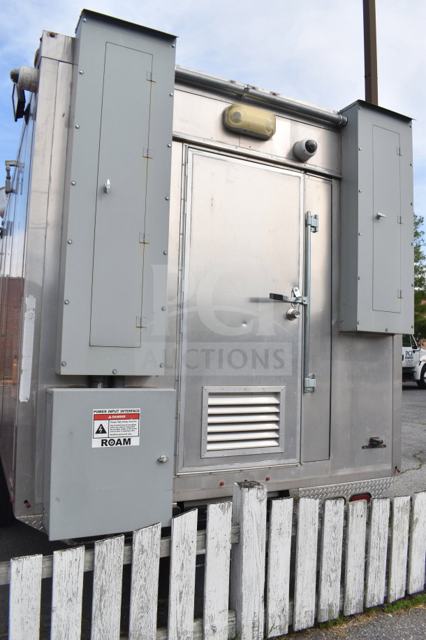 Alt text: "2021 Texino 28ft triple-axle cooking trailer exterior, featuring rear door and utility access boxes."