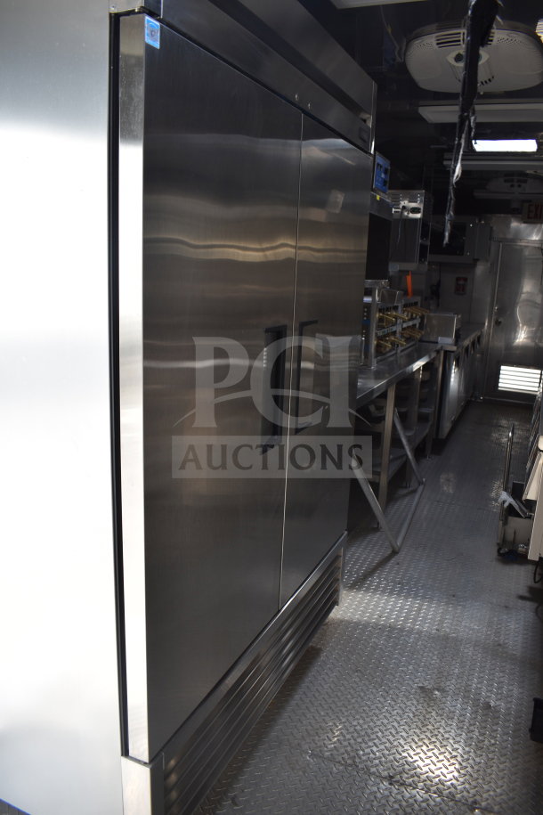 Interior of 2021 Texino 28ft cooking trailer showing True Refrigeration unit, stainless steel surfaces, and commercial kitchen setup.