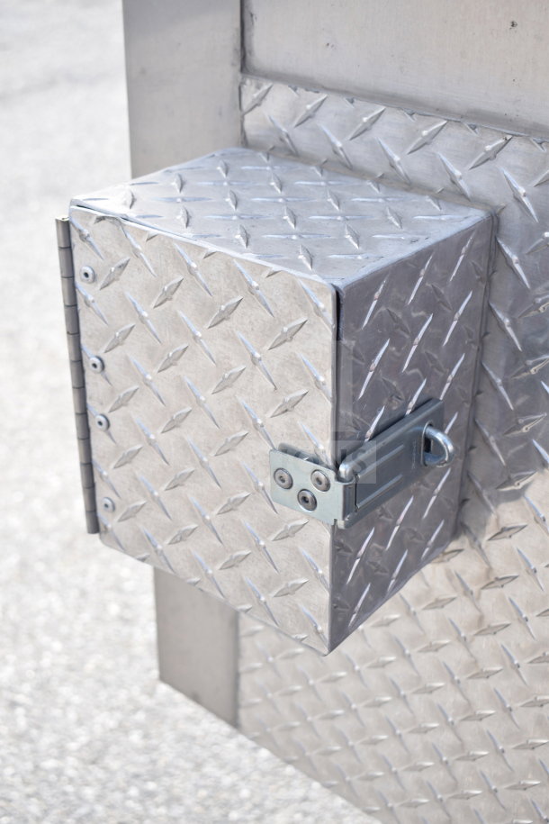 Diamond plate metal box with hinge and latch on Texino 28ft cooking trailer. Sturdy construction, part of 2021 model.