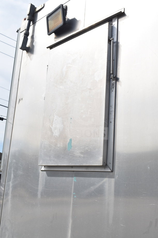 Exterior view of a 2021 Texino 28ft cooking trailer panel, featuring a light fixture and access panel.