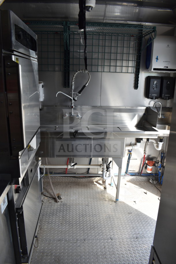 Interior of a 2021 Texino 28ft cooking trailer with a stainless steel sink, commercial faucet, and visible piping.