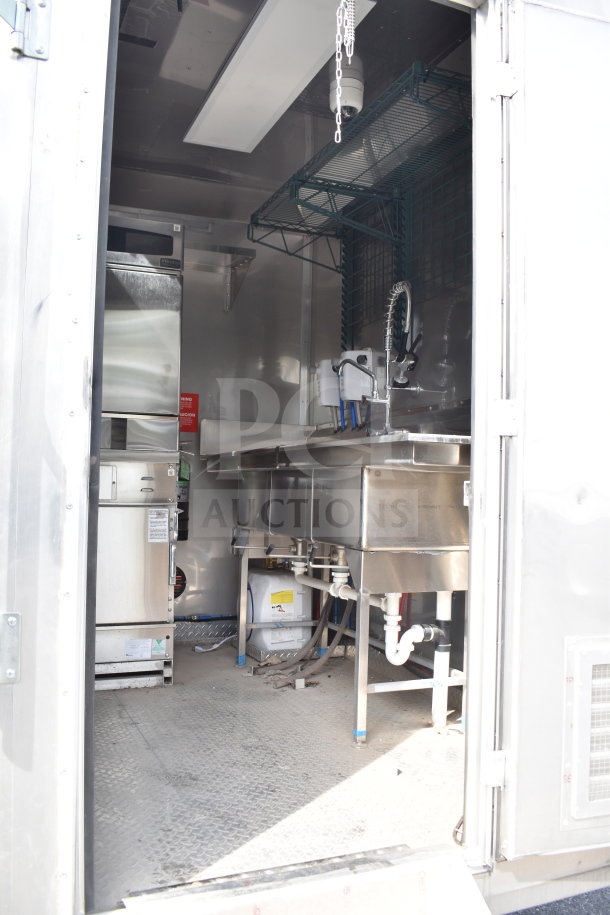 2021 Texino 28ft cooking trailer interior with stainless steel equipment, including a sink, fryer, and refrigeration units.