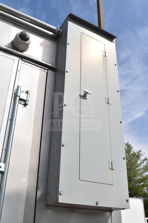 Exterior view of 2021 Texino 28ft Triple-Axle Cooking Trailer, featuring metal paneling and secure hardware.