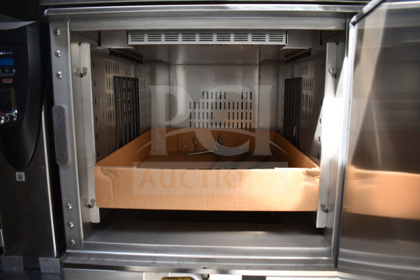 Inside view of a Winston CVap holding cabinet from the 2021 Texino cooking trailer, showing stainless steel interior and cardboard box.