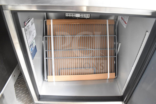 Inside view of a 2021 Texino cooking trailer's refrigeration unit with shelving and certified equipment labels visible.