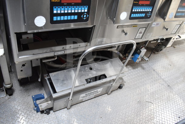 Alt text: Ultrafryer Ultrastat23 4-bay fryer in Texino 28ft cooking trailer, showing control panel, drain lever, and stainless steel build.