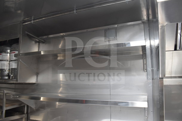 New 2021 Texino 28ft cooking trailer interior, featuring stainless steel shelving and fire suppression tank.