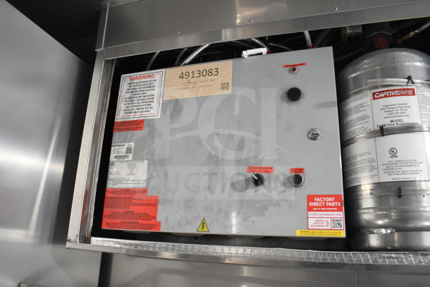 Texino cooking trailer control panel featuring safety warning labels, knobs, and CaptiveAire fire suppression system.