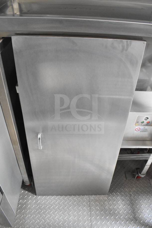 Stainless steel door of a 2021 Texino cooking trailer with diamond-patterned flooring.
