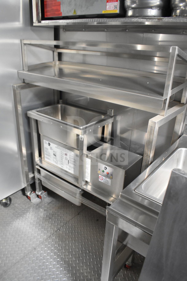 Texino 28ft cooking trailer interior with stainless steel shelving and equipment. Features Ultrafryer Ultrastat23 and CaptiveAire hood.