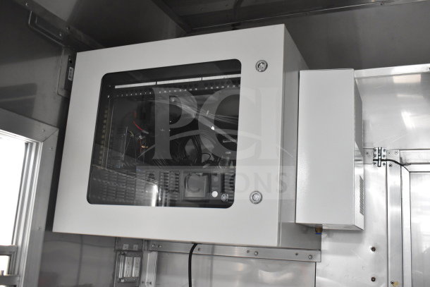 Interior view of a 2021 Texino 28ft cooking trailer control unit with visible wiring, secure metal casing, and clear display panel.