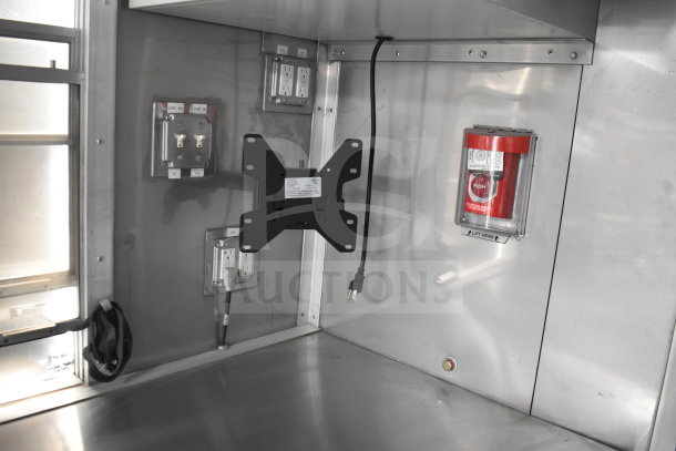 Interior view of a 2021 Texino cooking trailer with electrical outlets, a wall mount, and a fire alarm. Stainless steel finish.