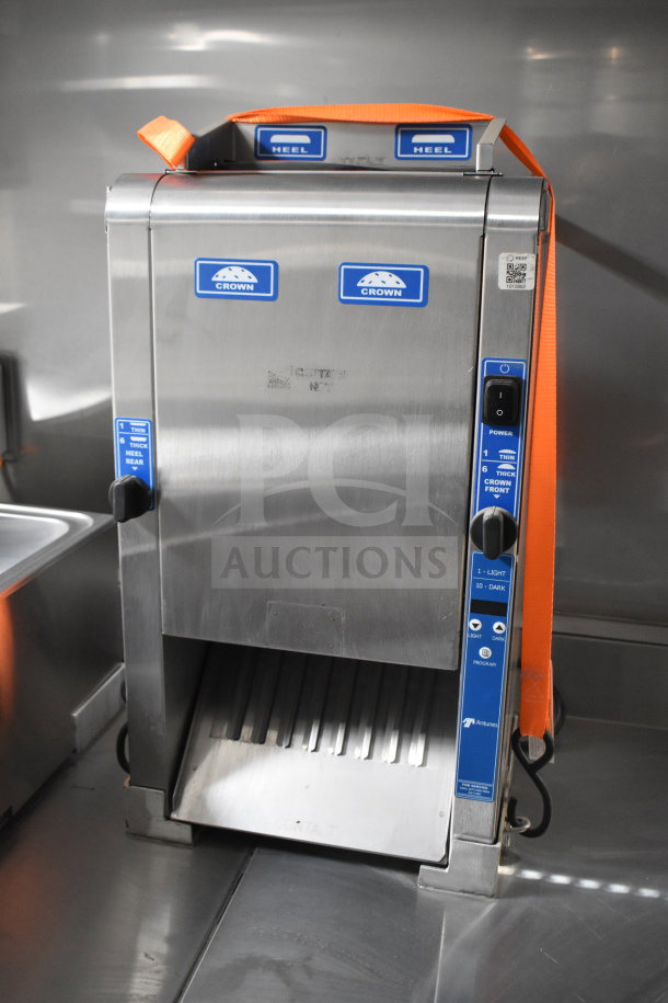 Stainless steel cooking appliance in the Texino trailer with labeled controls and orange securing strap.