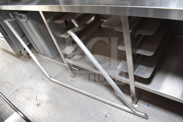 Stainless steel prep area inside 2021 Texino Popeyes-configured cooking trailer. Features shelving and sturdy construction.