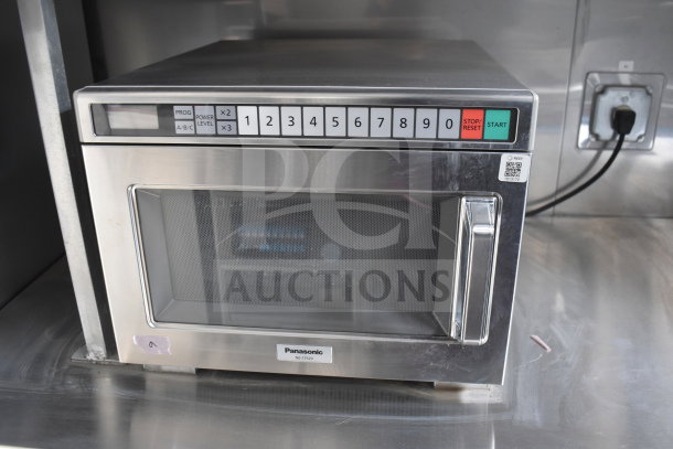 Panasonic NE-17523 commercial microwave with digital keypad, in excellent condition, mounted in a stainless steel kitchen setup.