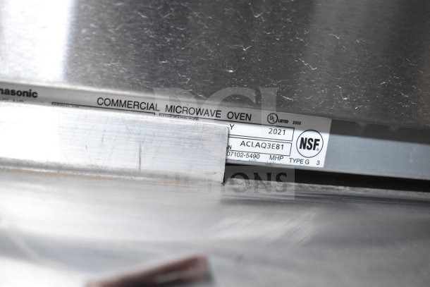 Label on a commercial microwave oven showing NSF certification and manufacture year 2021. Panasonic branding visible.