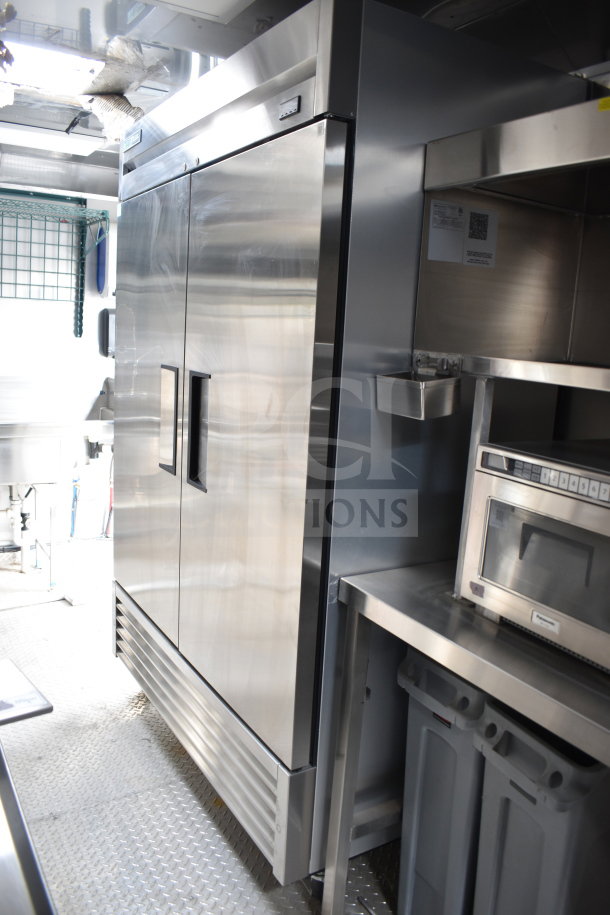 2021 Texino 28ft cooking trailer interior, featuring a True refrigeration unit and stainless steel equipment.