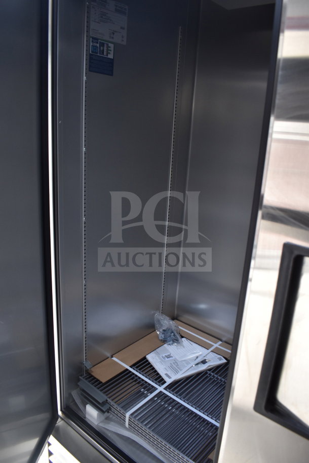 Interior of a Texino cooking trailer with shelving hardware, instruction manuals, and a clean, stainless steel finish.