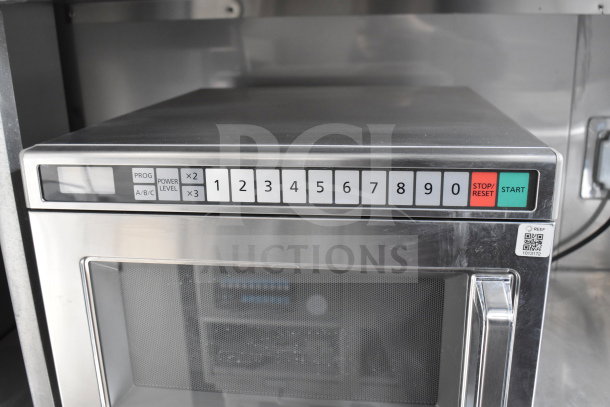 Control panel of a commercial microwave inside a Texino 28ft cooking trailer, featuring numbered buttons and start/stop controls.