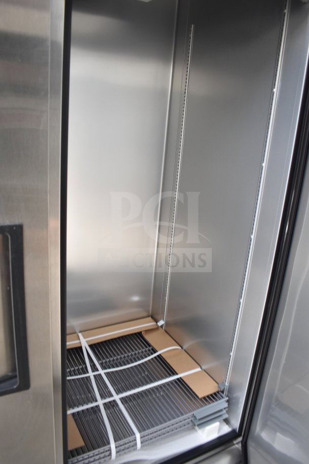 Interior of stainless steel refrigerator unit in the 2021 Texino 28ft cooking trailer, equipped for optimal storage.