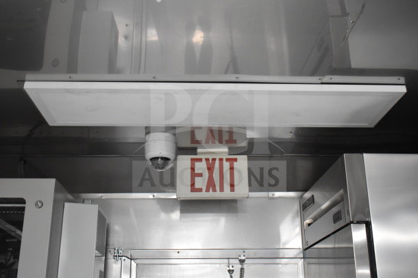 Interior view of a 2021 Texino 28ft cooking trailer featuring an exit sign and security camera.