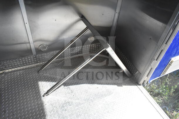 Rock Solid Cargo 8.5'x28' food trailer interior, featuring diamond plate flooring and stainless steel CaptiveAire grease hood.