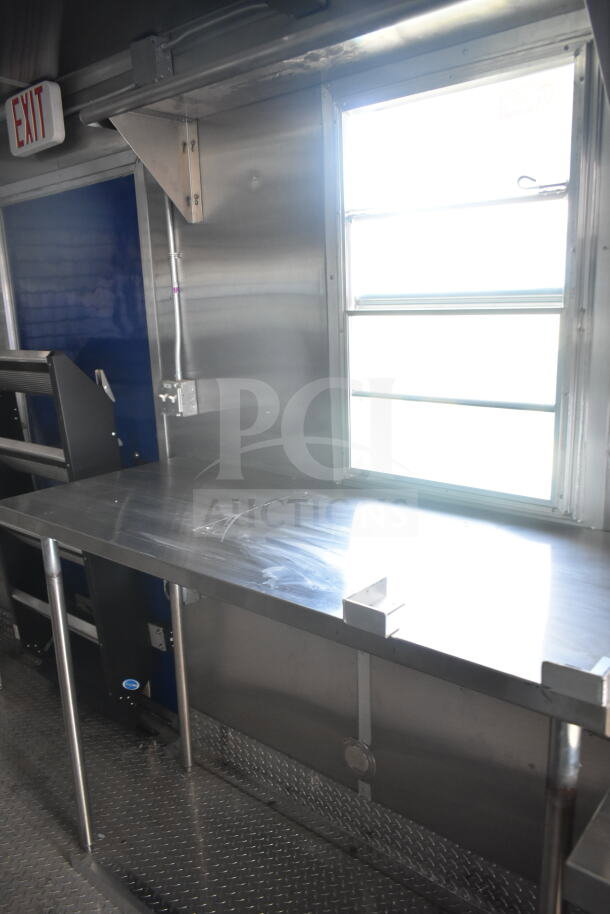 Rock Solid Cargo 8.5'x28' food trailer interior, featuring stainless steel counter and CaptiveAire grease hood for kitchen setup.