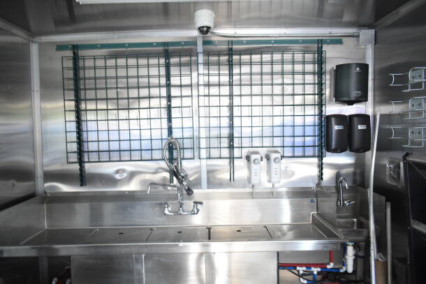 Rock Solid Cargo 8.5'x28' food trailer shell interior with stainless steel sinks, CaptiveAire grease hood, and dispensers.