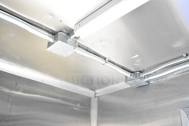 Rock Solid Cargo 8.5'x28' food trailer shell interior, showing metallic CaptiveAire grease hood system setup.