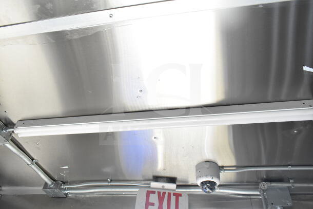 Rock Solid Cargo 8.5'x28' food trailer interior; stainless steel ceiling, CaptiveAire grease hood, and EXIT sign visible.