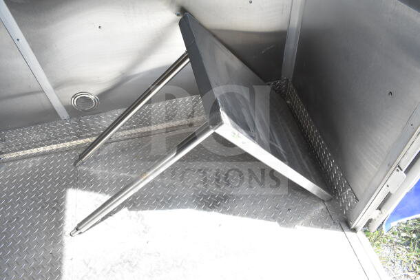 Interior of Rock Solid Cargo 8.5'x28' food trailer shell featuring metal wall and textured floor. Ready for customization.