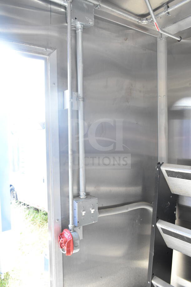 Rock Solid Cargo 8.5'x28' food trailer shell interior with CaptiveAire grease hood. Metal construction, wiring visible. Ready for customization.